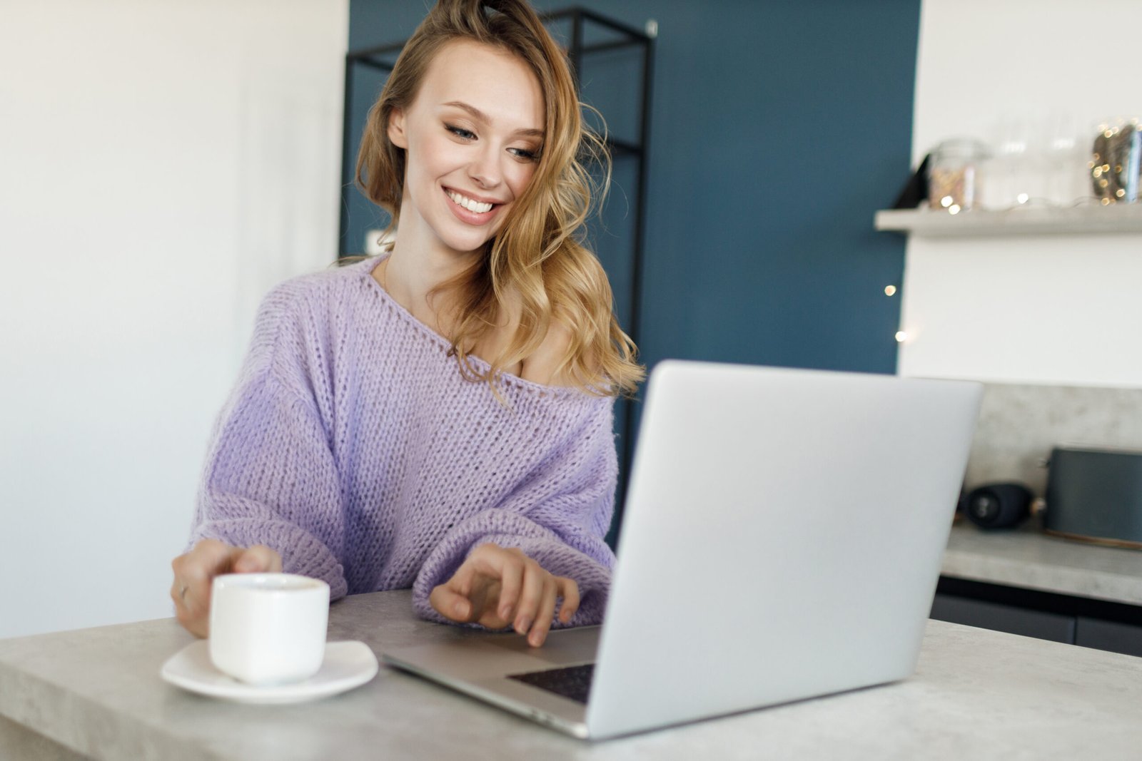woman smiling and typing on a laptop